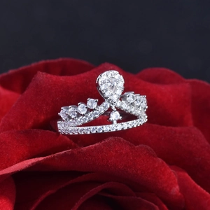 Elegant silver crown ring with pear-shaped cubic zirconia on red rose petals