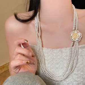 Detailed close-up of multi-layer pearl necklace with a delicate 3D flower accent for women