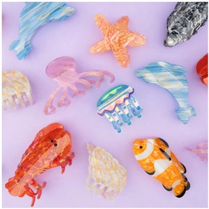 Flat lay of colorful acrylic ocean animal hair clips like starfish and dolphin shapes