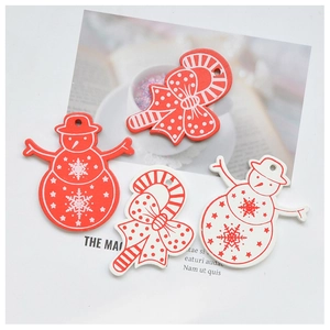 Close-up of red and white wooden Christmas ornaments featuring snowmen and candy canes