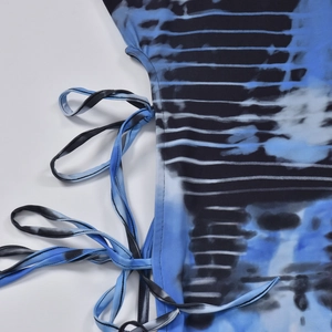Detail of side drawstring and blue-black gradient tie-dye pattern on bodycon dress