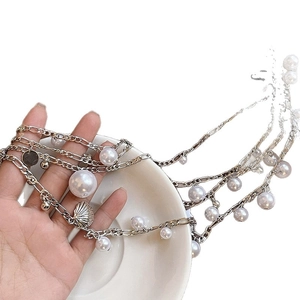 Silver double-layer waist chain with imitation pearls and shell pendants on white background