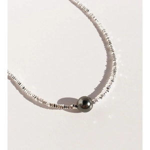 Minimalist silver necklace with bright silver beads and a central dark grey pearl pendant