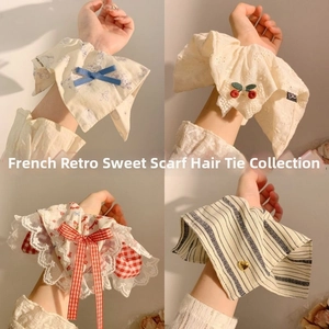Detail view of four French vintage floral and lace scrunchies displayed on a wrist