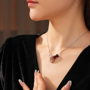 Bohemian titanium steel necklace with spotted stone pendant worn on a black velvet dress