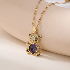Detail view of gold bear pendant with large purple gemstone and micro-paved cubic zirconia