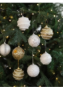 Macro shot of 9 mixed white and gold Christmas tree ornaments with pearls and sequins