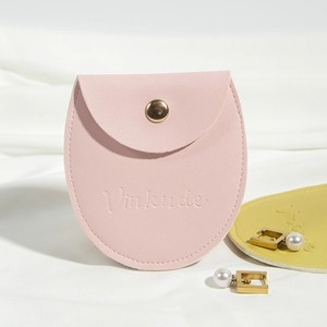 Detailed view of pink PU leather jewelry pouch with gold snap button and Vinknde logo