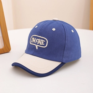 Détail d'une casquette bicolore bleu marine et beige avec broderie pour enfant