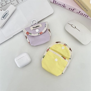 Close-up of fabric earphone pouches with snap buttons and floral bear pattern edges