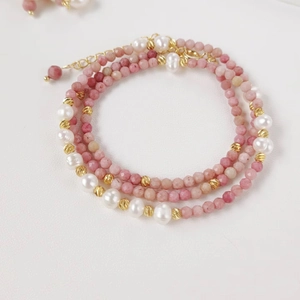 Detail view of pink natural stone and freshwater pearl necklace with adjustable gold clasp