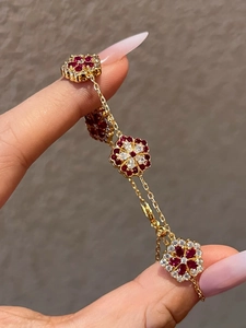 Detailed macro view of a gold-plated flower bracelet with ruby and zircon settings