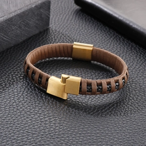 Detailed macro view of men's brown braided bracelet with gold magnetic metal clasp