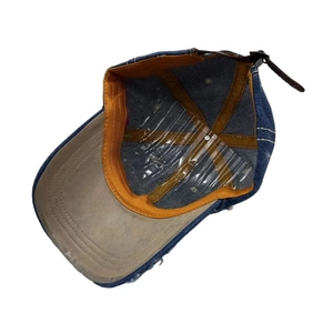 Blue denim baseball cap featuring an orange sweatband and brown leather back strap