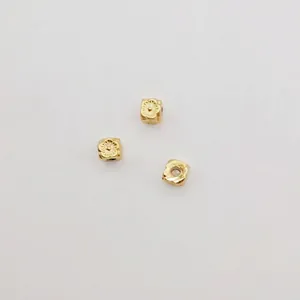 Three square gold floral spacer beads for DIY jewelry making on white background