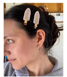 Detail of pink matte flower hair clips worn on side hair showing the metal duckbill clip