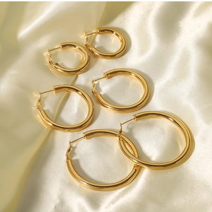 Three sizes of 18K gold plated stainless steel hoop earrings on luxury silk fabric