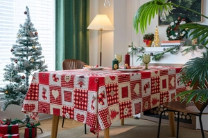 Close-up of Christmas tablecloth featuring red plaid, festive socks, and heart patterns