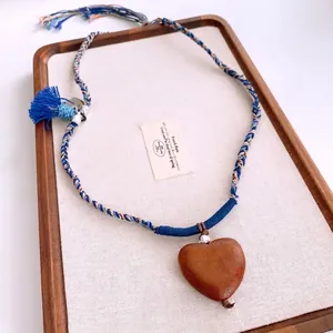 Ethic colorful rope necklace with a wooden heart pendant and stylish blue tassel