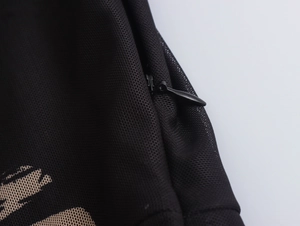 Detailopname van zwarte mesh-stof jurk met een hoogwaardige druppelvormige rits