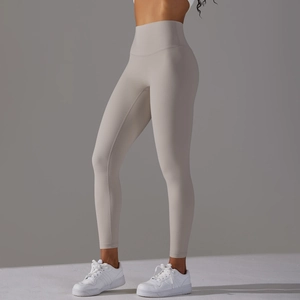 Detail of high-waisted light grey yoga pants showing seamless tummy control and matte fabric