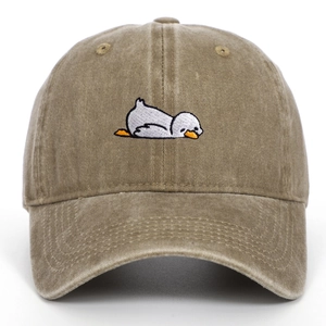 Detail of cartoon bird embroidery on vintage washed cotton baseball cap with ventilation holes