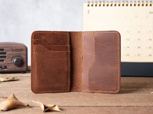 Detailed view of brown crazy horse leather card holder with multiple slots on wood surface