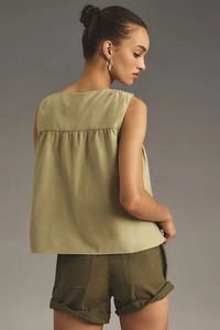 Detail of light olive green sleeveless top with pleated back and khaki casual shorts
