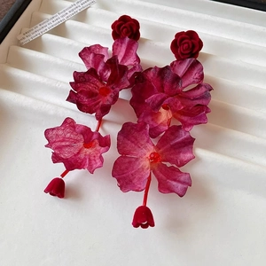 Orecchini retrò con rose in tessuto rosso e nappe in una scatola regalo bianca