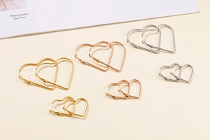 Detailed view of textured heart-shaped earrings in gold silver and rose gold finishes