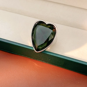 Macro detail of heart-shaped dark green gemstone set in a minimalist silver ring band