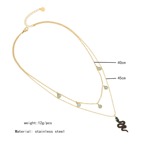 Detail showing gold double-layer chain with green stone and black snake pendant