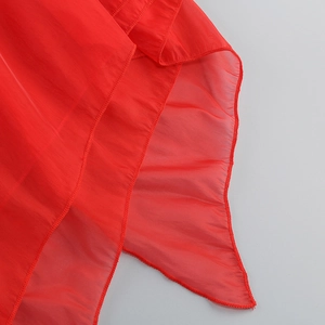 Gros plan détaillé des couches de mousseline rouge avec bords à volants finement ourlés