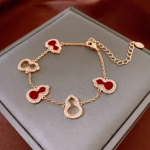 Elegant gold bracelet featuring five gourd pendants with red inlay and white zircon micro-pave