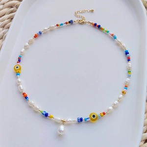 Bohemian colorful beaded necklace with freshwater pearls and evil eye charms on tray