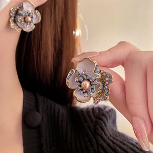Detail of vintage flower earrings with pearls and colorful rhinestones on model
