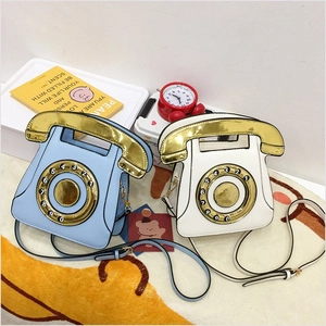 Detail of creative retro telephone shaped crossbody bags in blue and white colors
