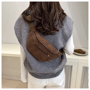 Brown corduroy waist bag with adjustable strap worn as a crossbody bag on a model