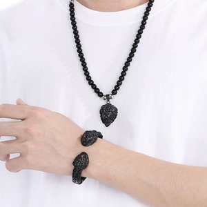 Detail of man wearing black onyx bead necklace and lion head cuff bracelet set