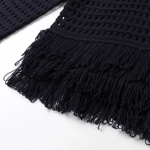 Detail of black hollow knit fabric featuring elegant long fringe and woven texture