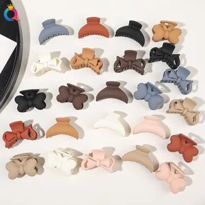 Multiple Morandi colored matte hair claws in bow and arched shapes on white background