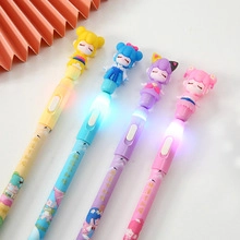 Detail of four colorful cartoon gel pens with glowing LED character tops on desk