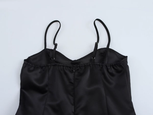 Detail of elegant black satin mini dress with thin straps and V-neckline back view