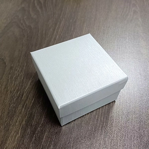 Detail of light blue square gift box with brushed texture finish on wooden surface