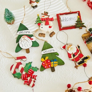 Detail of colorful wooden Christmas ornaments including Santa and Snowman on snow background