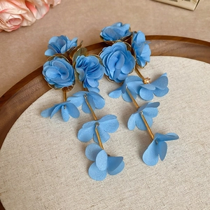 Detailed close-up of sky blue chiffon flower tassel earrings with golden chain links