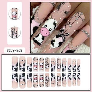 Long square press-on nails with cartoon cow patterns, black and white spots and glitter