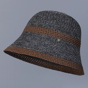 Detailed shot of a color-block woven sun hat with hollow brim and pearl flower ornament