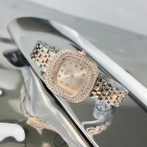 Detail of luxury square green watch with diamond bezel on rose gold and silver band