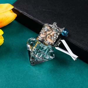 Macro detail of a diamond-cut crystal glass car diffuser bottle with a metal镂空lid